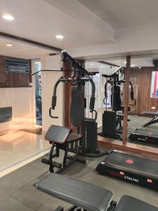a gym with several treadmills and a simulator at SRS Suites in Bangalore