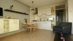 a kitchen and living room with a table and chairs at Appartement Boodtlaan 4E in De Koog