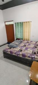 a large bed in a room with a window at Thakur place in Mathura