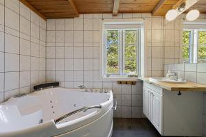 a bathroom with a tub and a sink at Kartveit Gjestetun in Manger +25 photos