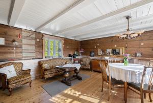 a large living room with a table and chairs at Kartveit Gjestetun in Manger