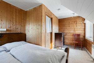 a bedroom with a bed and a chair in it at Kartveit Gjestetun in Manger