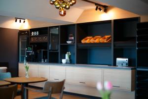 a kitchen with a counter with a table and chairs at Magnet Hotel in Schkeuditz