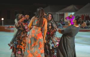 a group of women in dresses walking on a stage at Hostel Desert Camp Sam in Jaisalmer