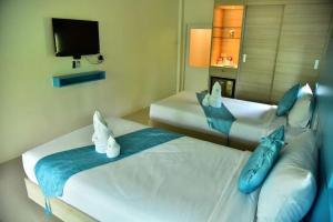 a hotel room with two beds and a tv at Social Escape Hotel Lemon Chalet in Ban Song Phi Nong