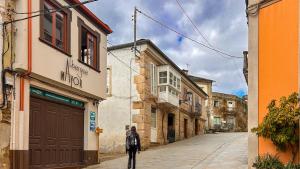 a man walking down a street in an alley at Albergue Mayor in Sarria +8 photos