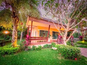 a house with a porch and a yard at Social Escape Hotel Lemon Chalet in Ban Song Phi Nong