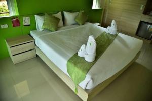 a large white bed with towels on top of it at Social Escape Hotel Lemon Chalet in Ban Song Phi Nong