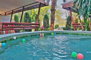 a swimming pool with colorful balls in the water at Social Escape Hotel Lemon Chalet in Ban Song Phi Nong
