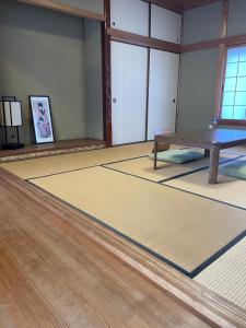 a room with a table and a wooden floor at 古民家宿誠makoto in Tamano