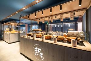 a buffet line with food on display in a restaurant at Hanting Hotel Guangzhou Tianhe in Guangzhou