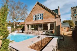 a brick house with a swimming pool in front of it at Finest Retreats - ARC Next-The-Sea in Wells next the Sea