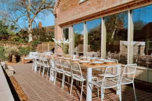 a long table and chairs on a patio at Finest Retreats - ARC Next-The-Sea in Wells next the Sea