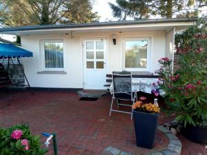 a white house with a patio with a table and chairs at Ferienhaus Eppler _ Objekt 25845 in Rostock
