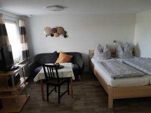 a bedroom with a bed and a chair and a television at Ferienhaus Eppler _ Objekt 25845 in Rostock +5 photos