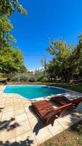 a swimming pool with a bench next to a swimming pool at Comarca Andina in Ciudad Lujan de Cuyo