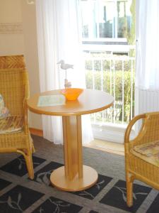 a table with a lamp on it in a room with a window at Pension Hermer in Grömitz