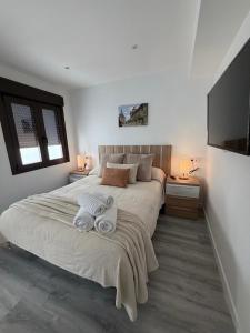 a bedroom with a large bed with towels on it at Apartamentos San Gabriel in Alcalá de Henares