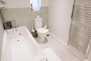 a bathroom with a toilet and a tub and a sink at Buckthorn Grove - 4 bed stunning home in Middlesbrough