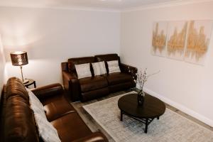 a living room with a couch and a table at Buckthorn Grove - 4 bed stunning home in Middlesbrough