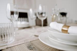 a table with white plates and a wine glass at Buckthorn Grove - 4 bed stunning home in Middlesbrough
