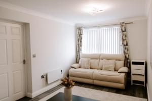 a living room with a couch and a window at Buckthorn Grove - 4 bed stunning home in Middlesbrough +38 photos