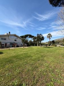 a large yard with a house and palm trees at Artemide Suite Spa in Lido Di Fondi