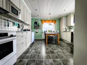 a kitchen with white cabinets and a table in it at Gästrum Vasaloppets vintervecka in Mora