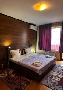 a bedroom with a large bed with a purple wall at Gelov Hotel in Berkovitsa +70 photos
