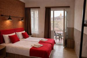 a bedroom with a large bed with a red headboard at Tbil Inn Hotel in Tbilisi City