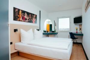 a bedroom with a white bed and a desk at Magnet Hotel in Schkeuditz +16 photos