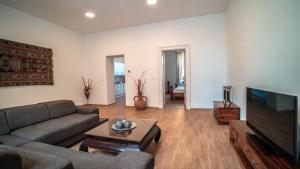 a living room with a couch and a flat screen tv at Peony Apartment in Kroměříž