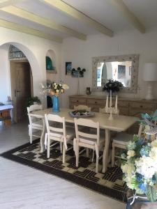 a dining room with a table and chairs with flowers at Apartment in a villa with a private pool in Cannigione