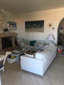 a living room with a white couch and a table at Apartment in a villa with a private pool in Cannigione