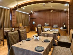 a restaurant with tables and chairs in a room at Hotel Wardhman in Jabalpur