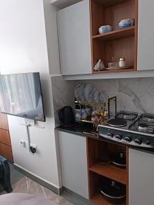 a kitchen with a stove and a tv in it at Cozy Studio Kiambu Town in Kiambu