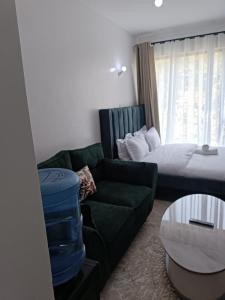 a living room with a couch and a bed at Cozy Studio Kiambu Town in Kiambu +5 photos