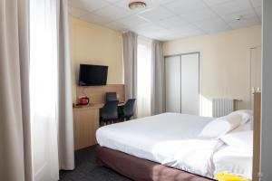 a hotel room with a bed and a tv at Hotel Kyriad Lamballe in Lamballe