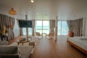 a living room with a couch and a large screen television at Beach Studio Level - WaveSide Ocean Bliss in Ko Phangan