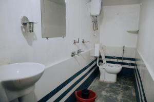 a bathroom with a white toilet and a sink at Hotel The TWB palace in Gwalior