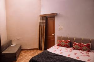 a small room with a bed and a bench and a door at Hotel The TWB palace in Gwalior