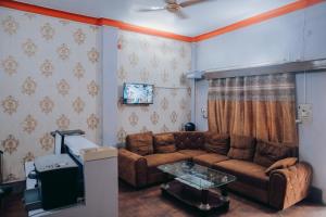a living room with a couch and a table at Hotel The TWB palace in Gwalior +4 photos