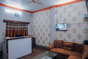 a living room with a couch and a flat screen tv at Hotel The TWB palace in Gwalior