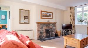 a living room with a fireplace and a tv at Greenhowes at the Graythwaite Estate in Ulverston