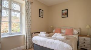 a bedroom with a bed with towels on it at Greenhowes at the Graythwaite Estate in Ulverston +33 photos