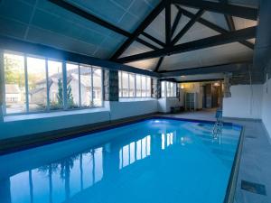a large swimming pool with blue water in a building at Greenhowes at the Graythwaite Estate in Ulverston