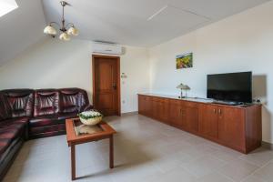 a living room with a couch and a flat screen tv at Private Vendégház in Villány