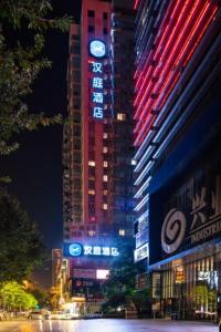 a tall building with a clock on it at night at Hanting Hotel Guangzhou Tianhe in Guangzhou