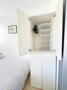 a small bedroom with a bed and white cabinets at Studio à Canet Plage 200m Mer Balcon in Canet-en-Roussillon