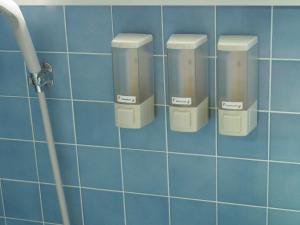 a blue tiled wall with three soap dispensers on it at Riad Camellia in Mitoyo
